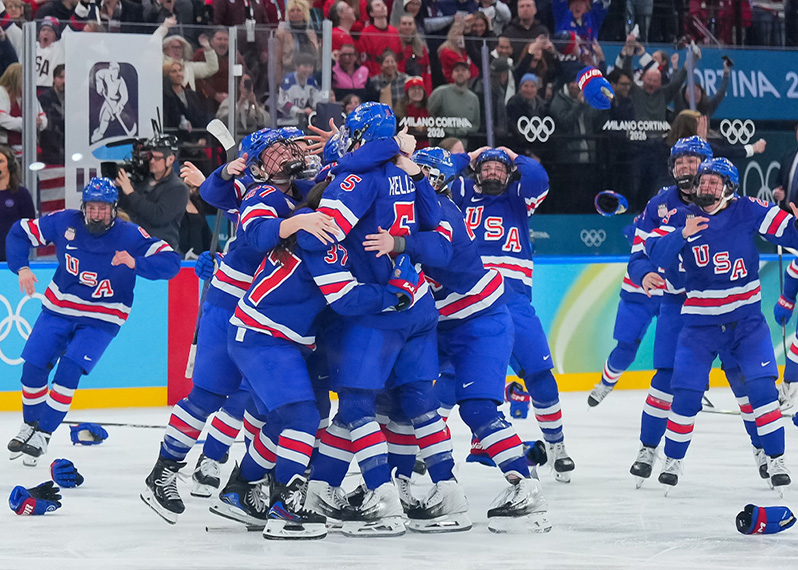 USA's Megan Keller celebrates with teammates after scoring the 2-1 overtime-winning goal against Canada during Gold Medal Game at the Milano Cortina 2026 Olympic Winter Games. Credit: Andre Ringuette